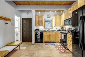 A kitchen with wooden cabinets, a dishwasher, a microwave, a stove, and a refrigerator.