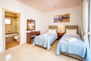 Ein Hotelzimmer mit zwei Betten, einem Badezimmer und einem großen Fenster.