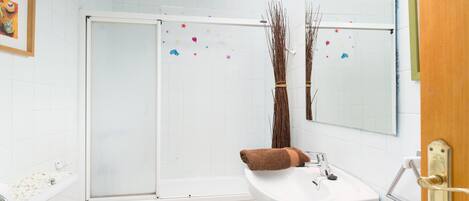 Une salle de bain équipée de toilettes, d’un lavabo et d’une douche.