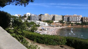 Eine Küstenstadt mit Strand, Hochhotels und üppiger Vegetation.