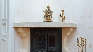 A corner fireplace with a decorative mantel, a large shell, and a candelabra.