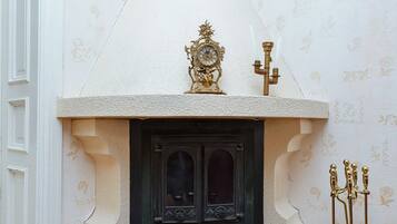 A corner fireplace with a decorative mantel, a large shell, and a candelabra.