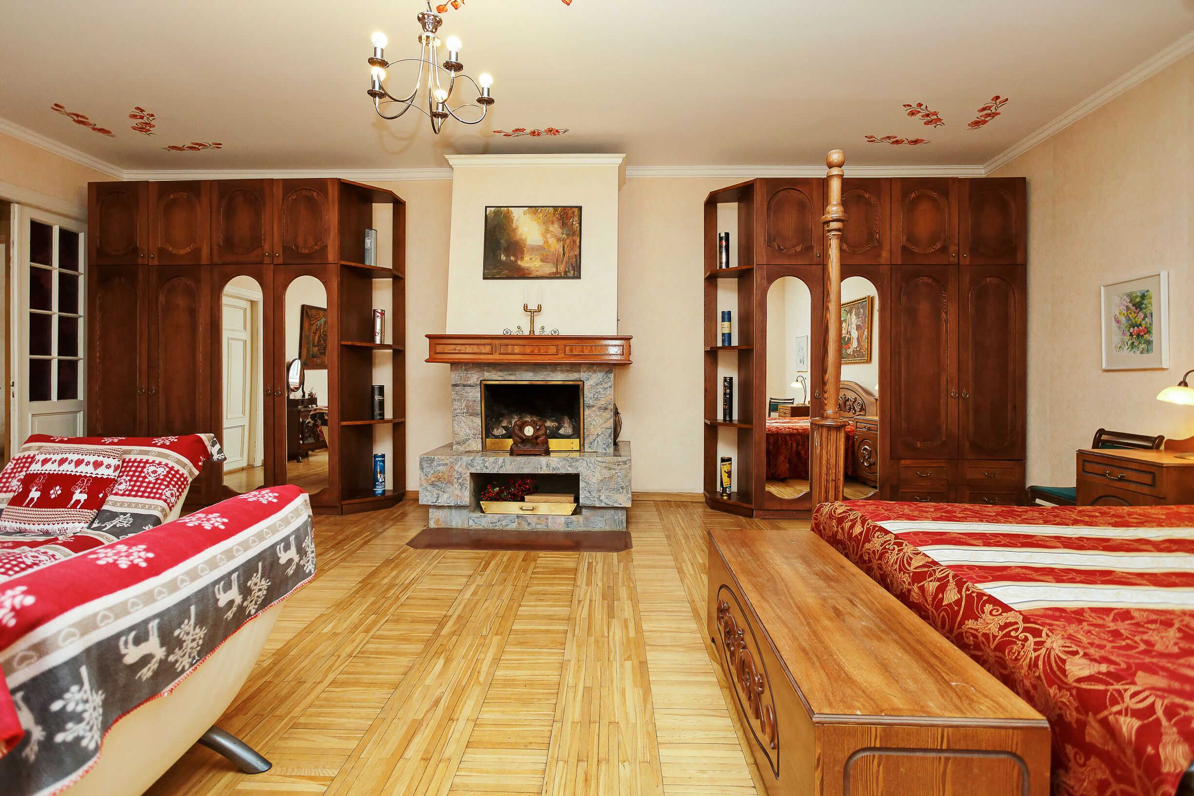A traditional room with a fireplace, wooden furniture, and a chandelier.