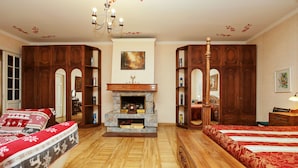 A traditional room with a fireplace, wooden furniture, and a chandelier.