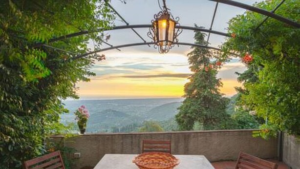A patio with a table and chairs, a hanging lantern, and a view of the landscape. - Santa Lucia Suite, apartment with lovely view over the shore (Santa Lucia)