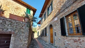 A narrow cobblestone street flanked by stone buildings with wooden doors and shutters. - Santa Lucia Suite, apartment with lovely view over the shore (Santa Lucia)