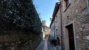 A narrow cobblestone alley flanked by stone buildings with arched doorways and a brick pathway. - Santa Lucia Suite, apartment with lovely view over the shore (Santa Lucia)