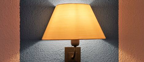 Una lámpara de pared con base de madera y pantalla de tela.