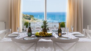 Ein Tisch für zwei mit Meerblick, eine Ananas und eine Weinflasche.