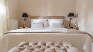 Ein ordentlich bezogenes Bett mit einer gepolsterten Kopfteile, zwei Nachttischlampen und einem Schild mit der Aufschrift 'SWEET HOME'.