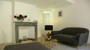 Ein modernes Wohnzimmer mit Kamin, einer Couch und einer Lampe.
