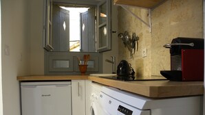 Eine kompakte Küche mit Geschirrspüler, Waschmaschine und einer Holzauskładfläche.