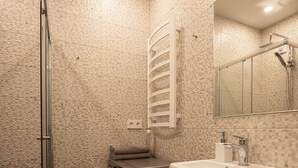 Un baño moderno con ducha, lavadora integrada, lavabo y espejo.