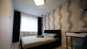 Un dormitorio moderno con cama, escritorio y pared con diseño.