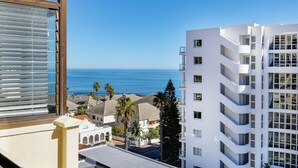 Un edificio alto con varios balcones con vista a la costa.