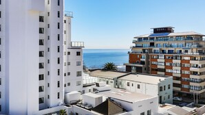 Un edificio alto con múltiples balcones que dan a la costa.