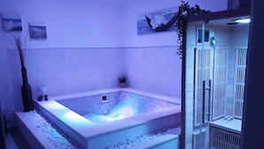 Une salle de bain moderne avec une baignoire sur pieds, un espace douche et des plantes décoratives.
