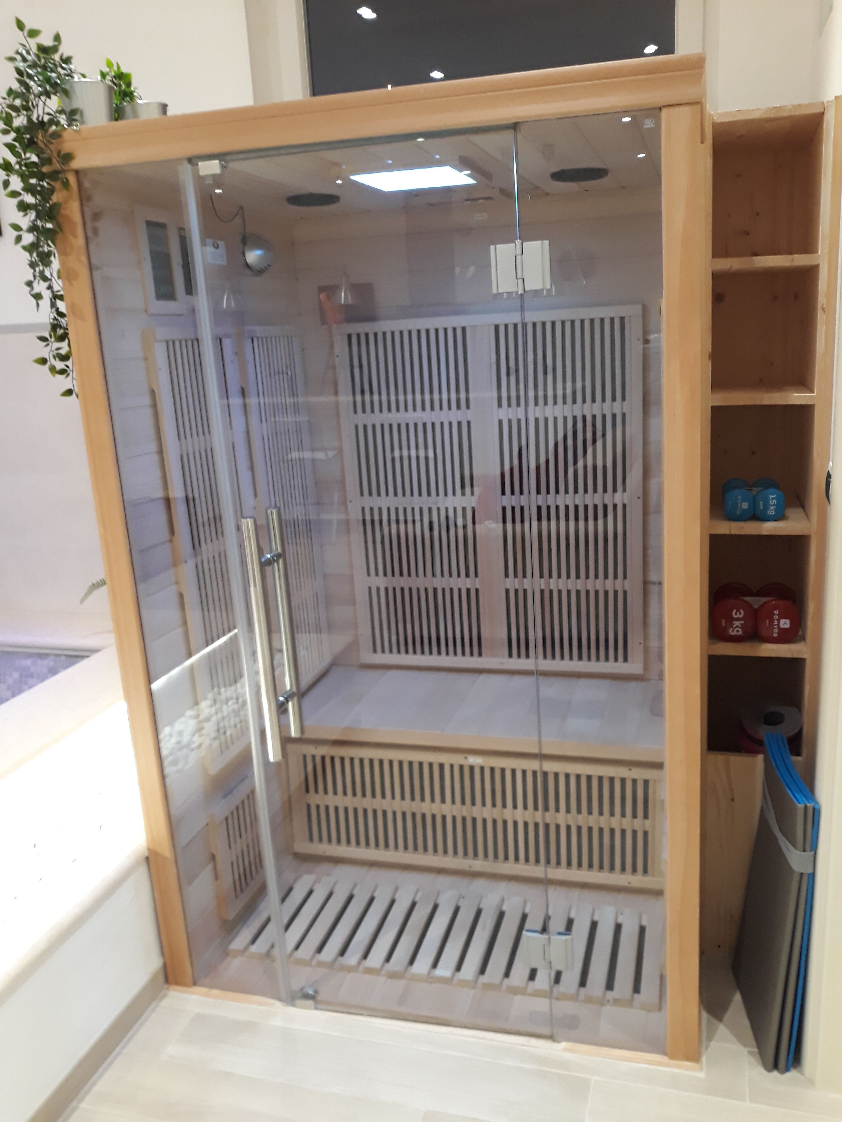 Un vestidor amplio con armario espejado, sistema de ventilación y estantes con pesas.