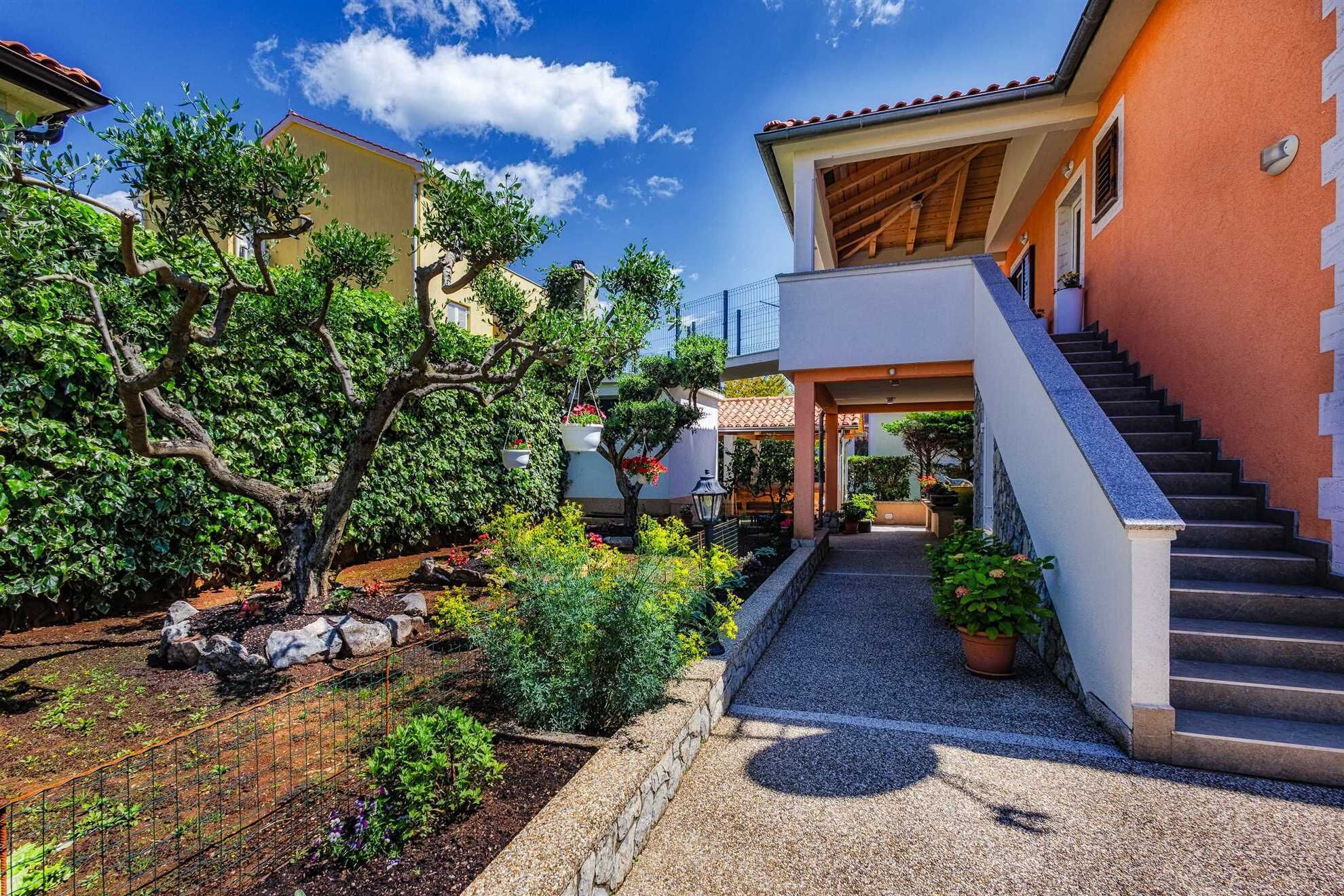 A courtyard with a gravel path leading to a staircase.