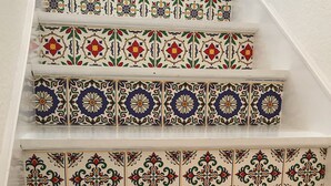 A staircase with ornate, colorful tiles featuring floral and geometric patterns.