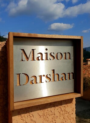 A sign with the name "Maison Darshan" mounted on a wooden structure. - Maison Darshan: Peace, nature and holidays. (Collobrières)