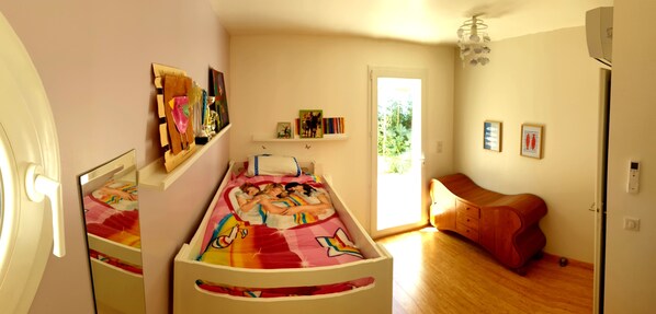 A child's bedroom with a bunk bed, a wooden dresser, and a door leading to a balcony. - Maison Darshan: Peace, nature and holidays. (Collobrières)