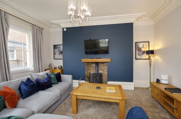 A living room with a sofa, a coffee table, a fireplace, a television, and a lamp. - Patricks Pool Town House-4 Bed/4 Bath - sleeps 8 guests in 4 bedrooms (York)