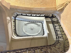 A staircase with ornate metal railings and a decorative ceiling.