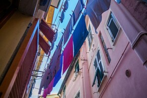 A narrow street with buildings on either side, featuring balconies and windows. - Casa Pina Quiet Apartment (Vernazza)