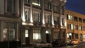 Un edificio de varios pisos con arquitectura clásica, que cuenta con ventanas amplias y una entrada central.
