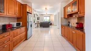A modern kitchen with wooden cabinets, a stainless steel refrigerator, and a microwave.