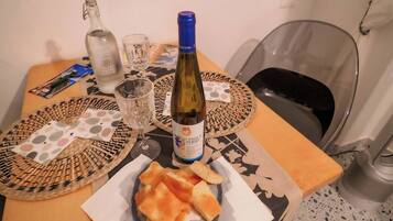 Ein Tisch mit einer Weinflasche, Gläsern und einer Brotschale.