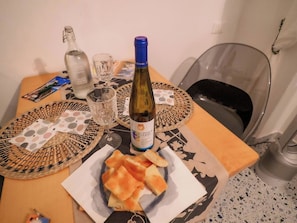 Ein Tisch mit einer Weinflasche, Gläsern und einer Brotschale.