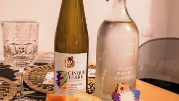 Een tafel met een fles wijn, een waterfles en een broodplank.