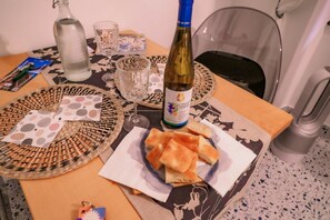 Ein Esstisch mit einer Weinflasche, Gläsern und Brot.