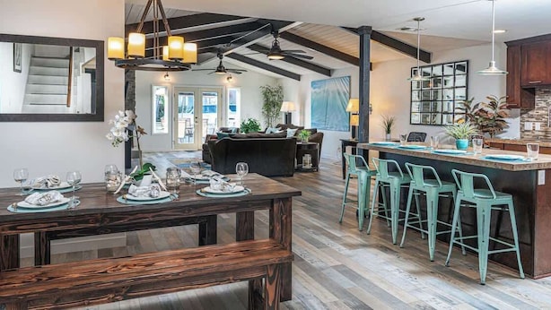 A spacious kitchen with a central island, bar stools, and a dining area with a wooden bench. - Newport Beach Balboa House with Large Patio, Walk to Lido Village (Newport Beach)