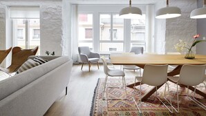 A modern living room with a sofa, chairs, a dining table, and a patterned rug. - Marugame by FeelFree Rentals (San Sebastián)