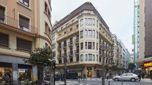 A corner building with multiple floors, balconies, and a storefront with a sign. - Marugame by FeelFree Rentals (San Sebastián)