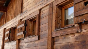 A wooden cabin with multiple windows and a visible door.