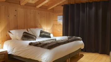 A wooden cabin-style bedroom with a bed, pillows, and a fur throw.
