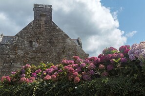 Un edificio de piedra con techo triangular y chimenea.