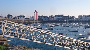 A bridge over a marina with boats, a lighthouse, and buildings in the background. - GROUND FLOOR, 3 BEDROOMS, 5 MINUTES FROM THE BEACH, DOG ALLOWED (Treffiagat)