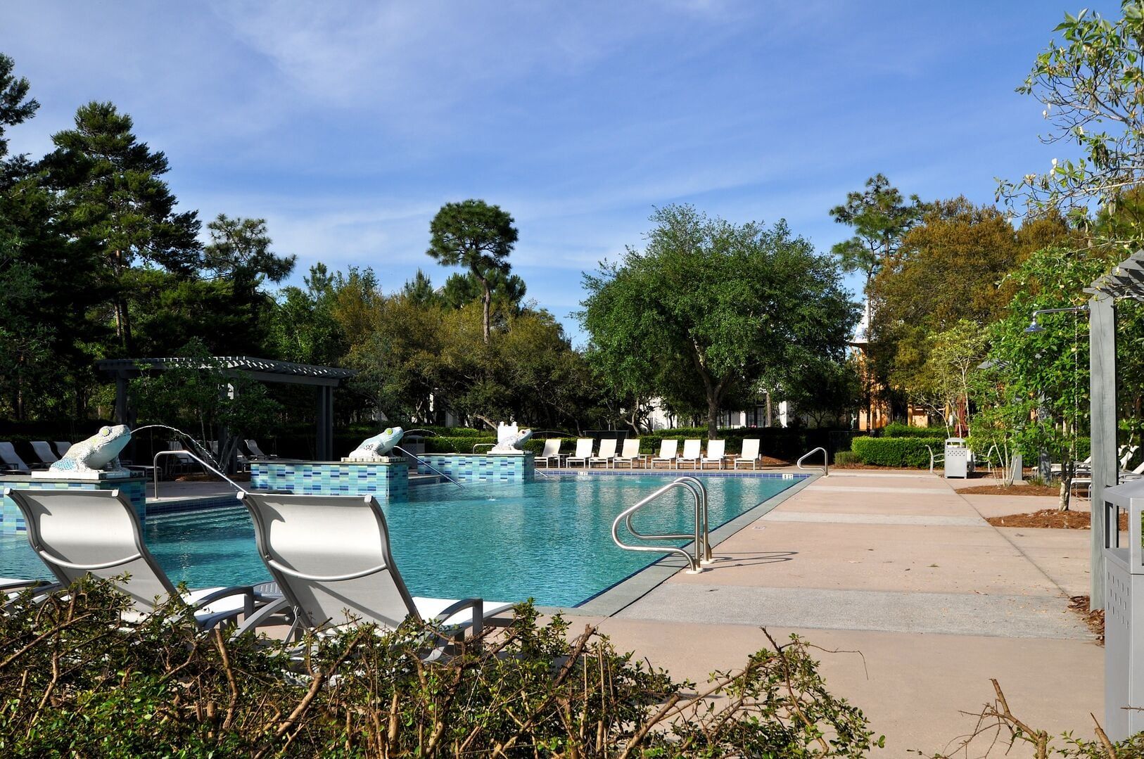 A swimming pool with lounge chairs and a water feature.