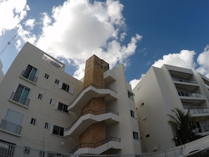 Stunning multi-story building with a unique architectural design, featuring a central tower and balconies on each floor.