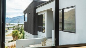 Une maison moderne dotée de grandes fenêtres et offrant une vue sur les montagnes.