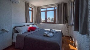Ein Hotelzimmer mit Bett, Fenster und Pflanze.
