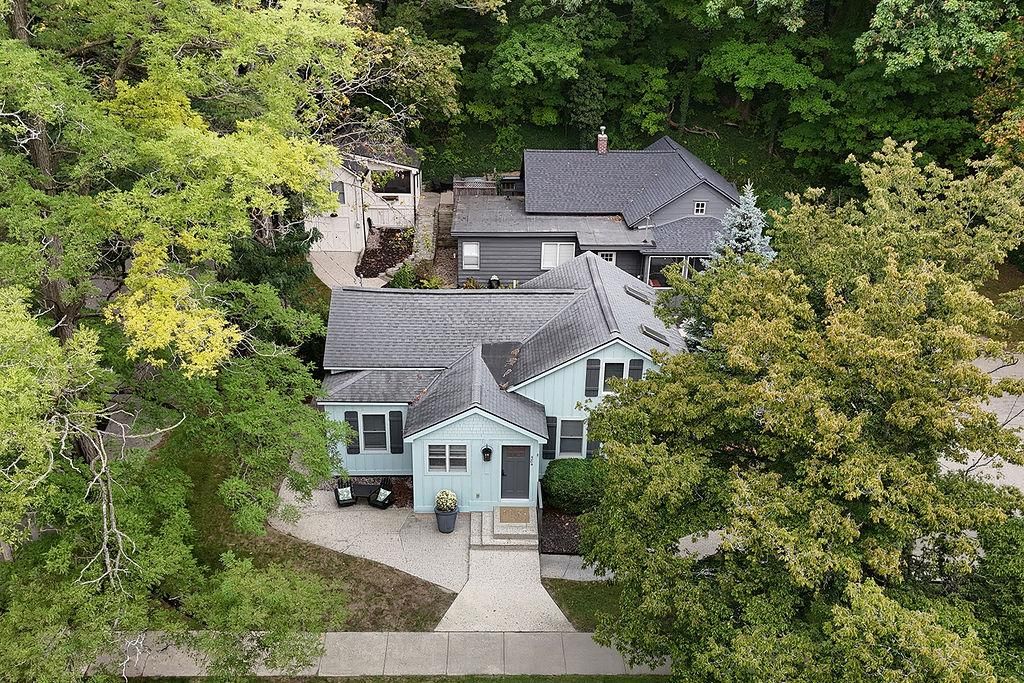 A residential property with a two-story house, a covered porch, and a driveway.