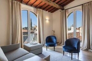 A room with a sofa, two chairs, a small table, and large windows with curtains. - Villa Michelangelo with swimming pool (Firenze)