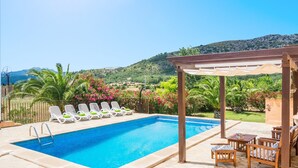 A swimming pool with lounge chairs and a pergola, surrounded by greenery and hills. - CAN CORRÓ - Villa with private pool in Alcudia. Free WiFi (Alcúdia)