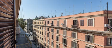 A row of traditional buildings with uniform window shutters and balconies, typical of historic European architecture.